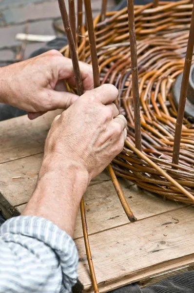 Мужские руки, делая плетеной корзине — стоковое фото