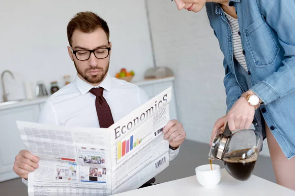 Бизнесмен Очки Чтение Газеты Экономика Пока Жена Разлива Кофе Чашке — стоковое фото