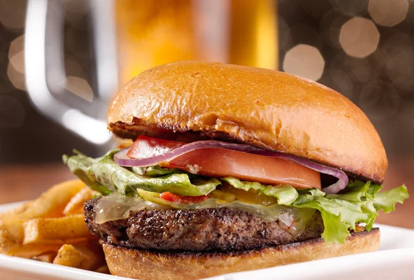 Изысканные чизбургер с кружкой пива в фоновом режиме — стоковое фото